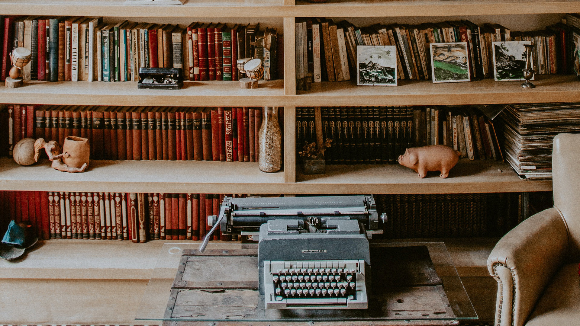 a typewriter in front of a bookshelf